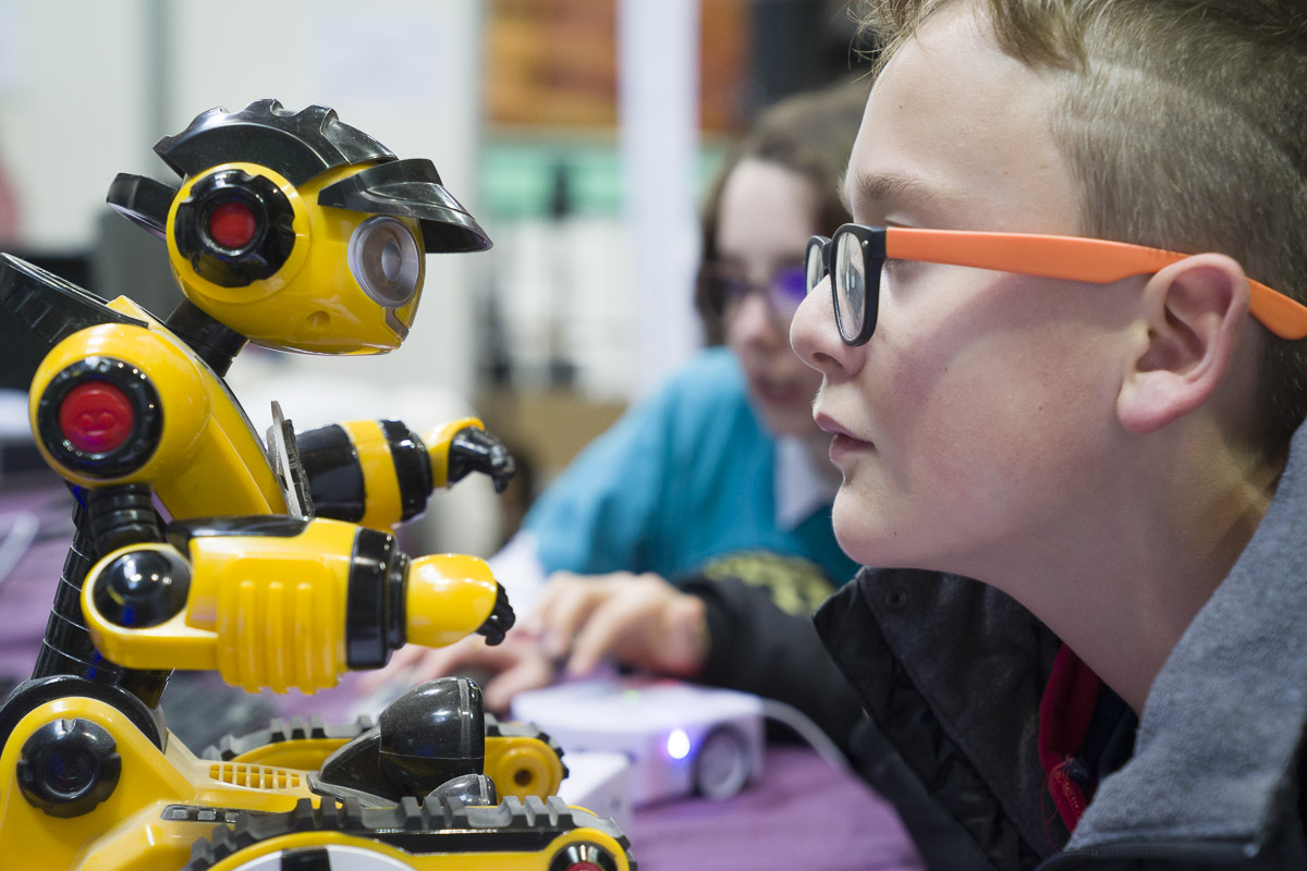 Enfant face à face avec un robot jaune
